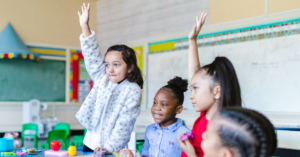 Students raising their hands in the classroom